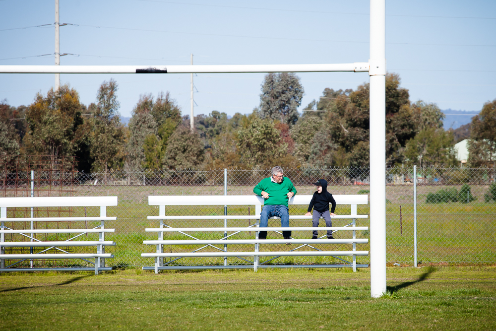 adult and child sitting in bleachers - Documentary Family Photography