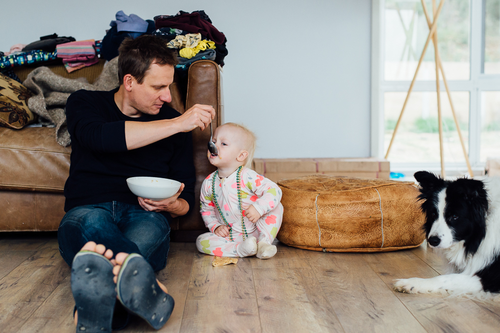 father feeding baby on floor - Documentary Family Photography