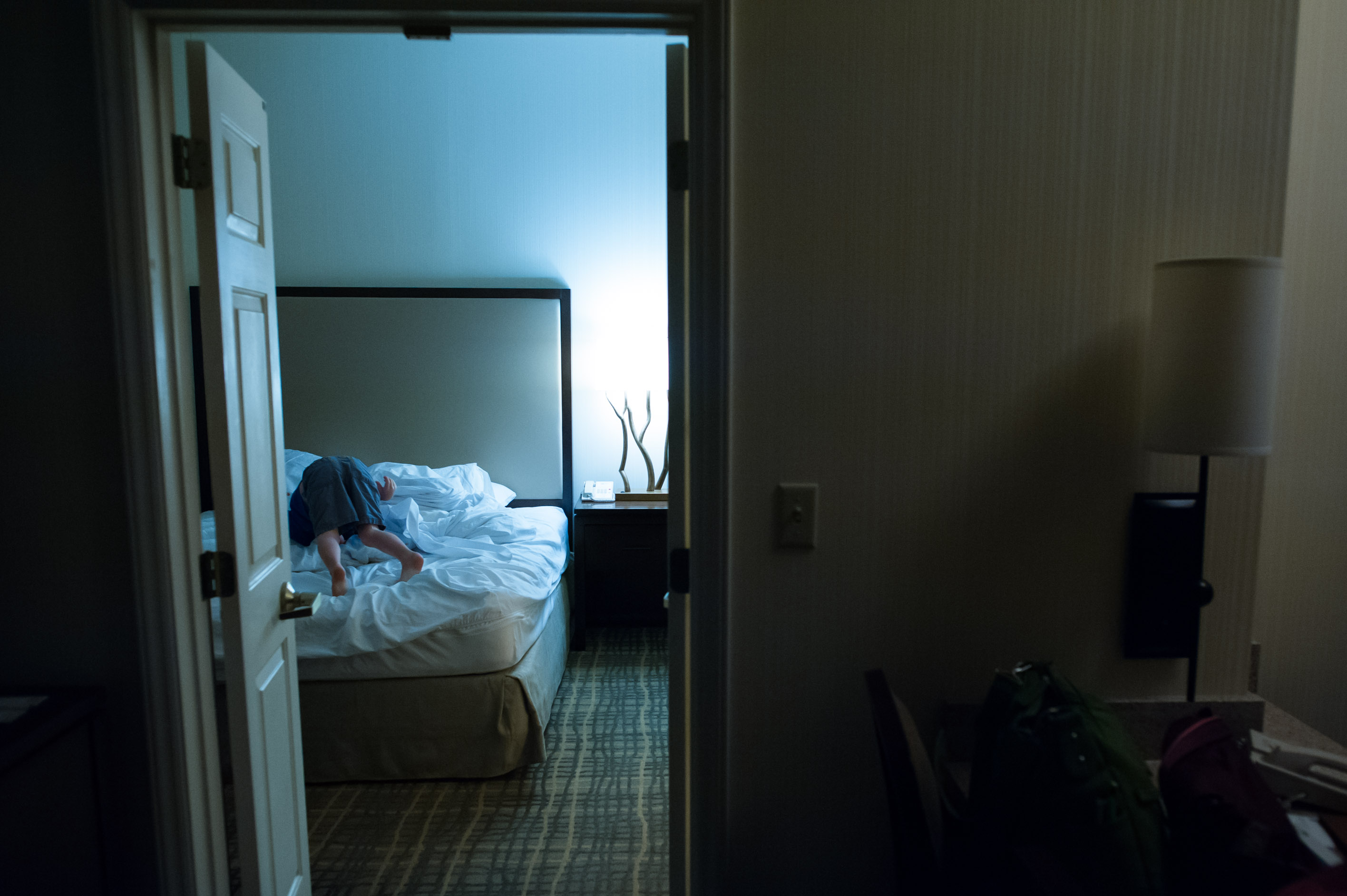 child rolling on bed - Documentary Family Photography