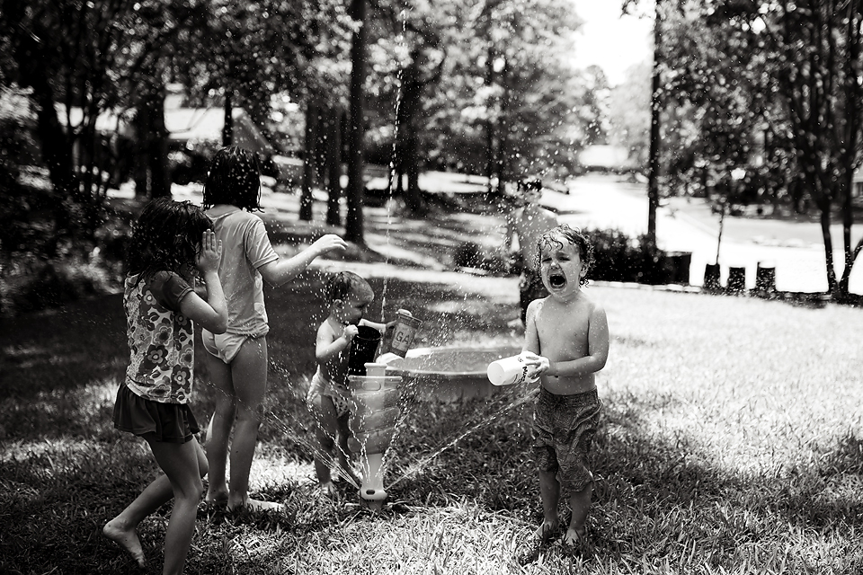 angry child at sprinkler - Documentary Family Photography