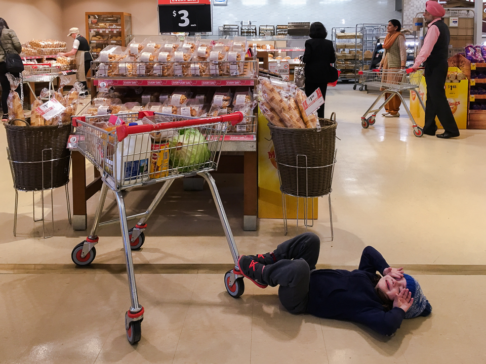 child throws tantrum in grocery store - Documentary Family Photography