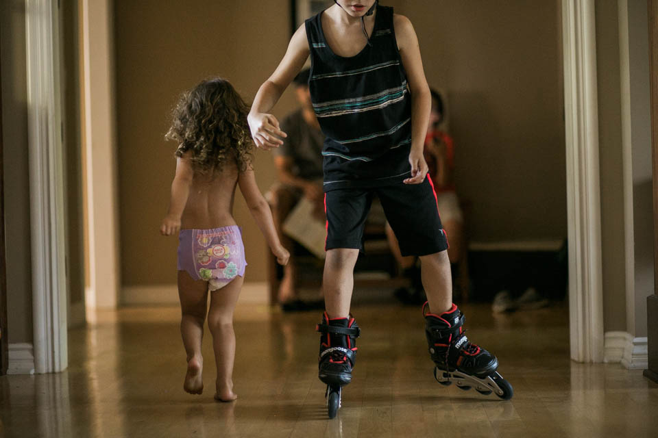 kid rollerblading in house - Documentary Family Photography