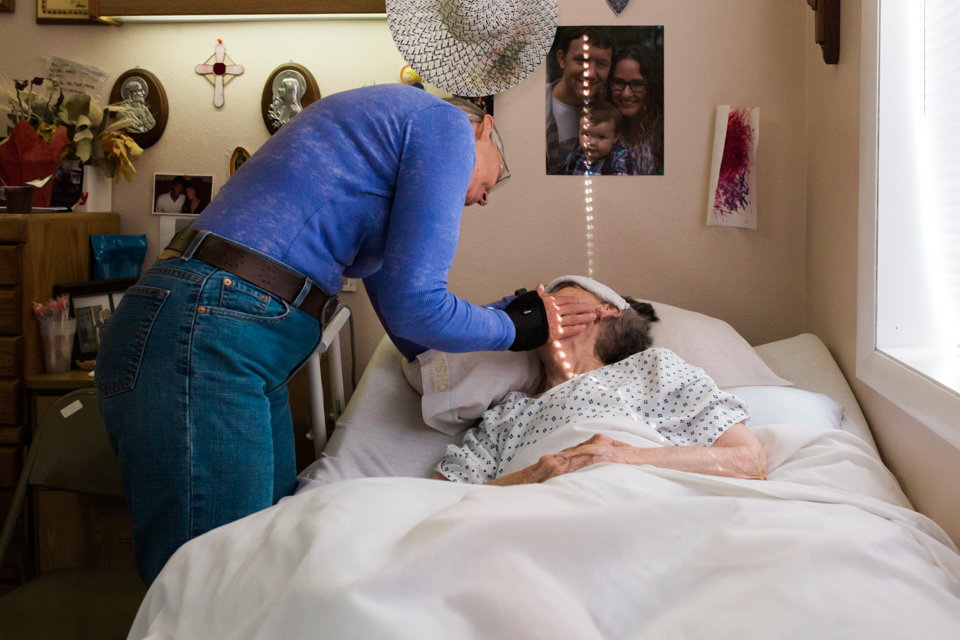 woman speaks with elderly woman in bed - Lacey Monroe - Documentary