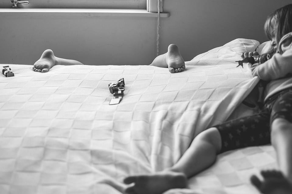 kid's feet as seen over top of bed