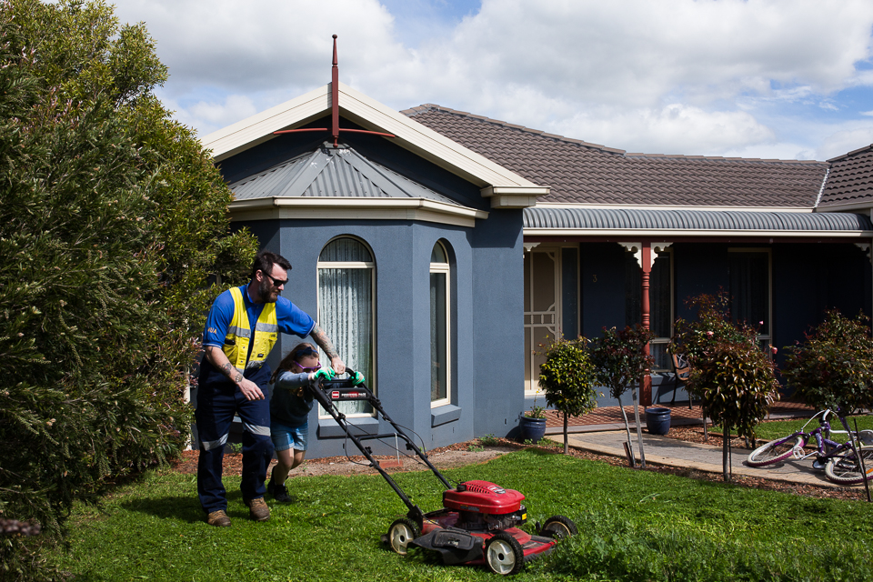 child mows grass with father - Documentary Family Photography