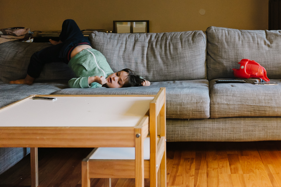 boy rolling around on couch - Documentary Family Photography