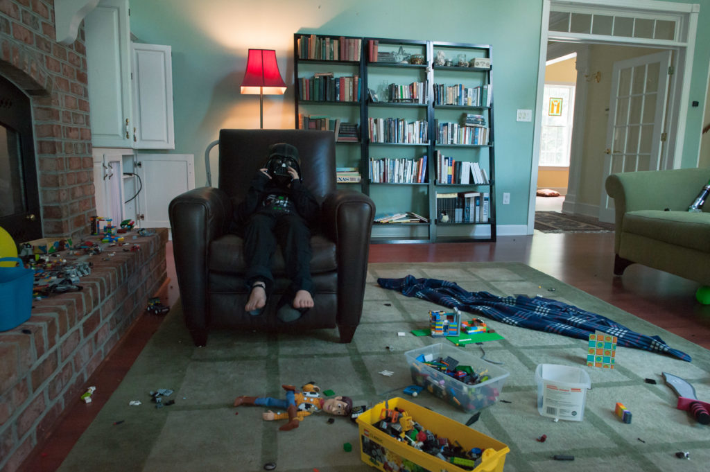 boy in darth vader costume sits in living room - Documentary Family Photography