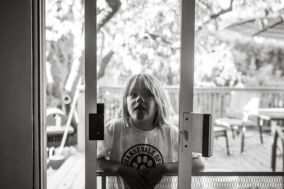 girl presses face on window - Documentary Family Photography