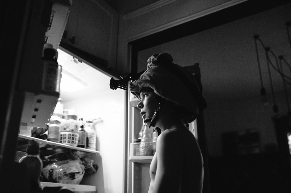 boy in helmet looks in fridge - Documentary Family Photography