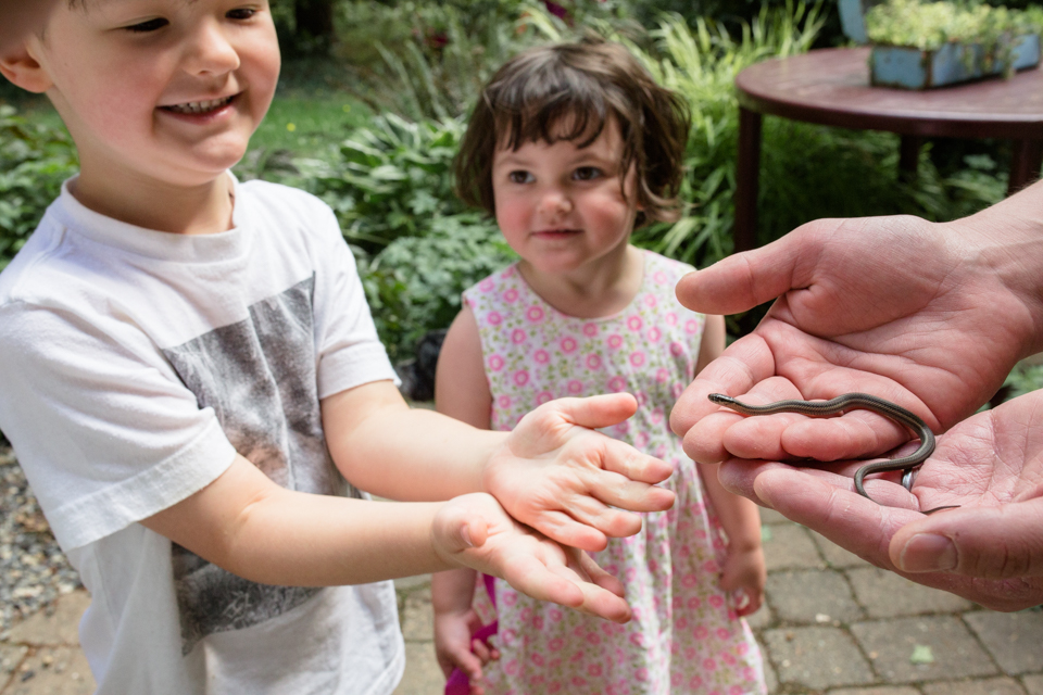 little boy holding a snake with little girl looking on