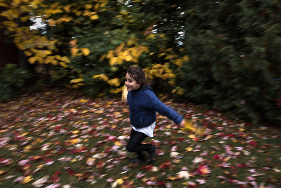girl runs with leaves - Documentary Family Photography