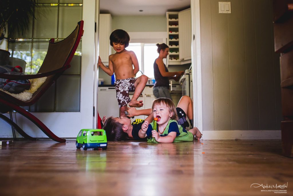kids rolling around on floor - Documentary Family Photography