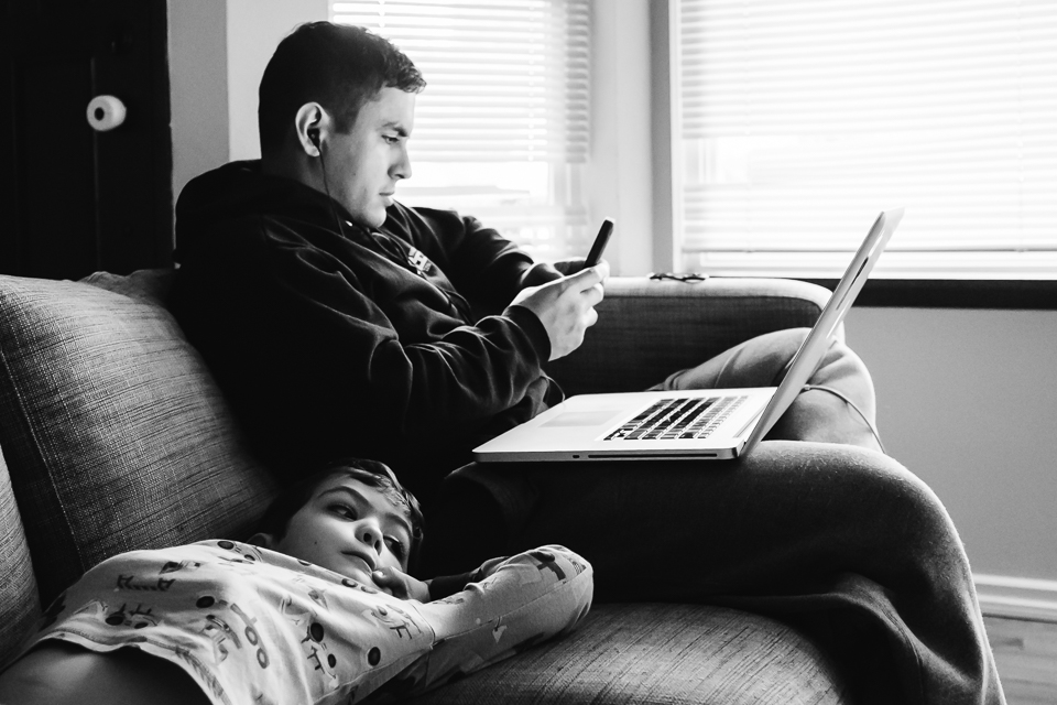 boy on couch with father at laptop - Documentary Family Photography