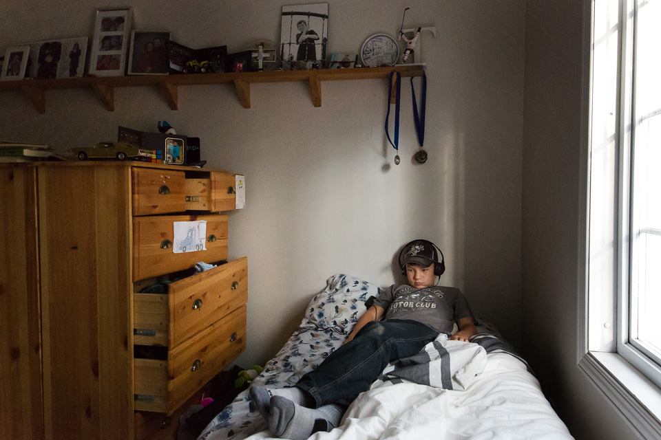 boy on bed with headphones - Documentary Family Photography