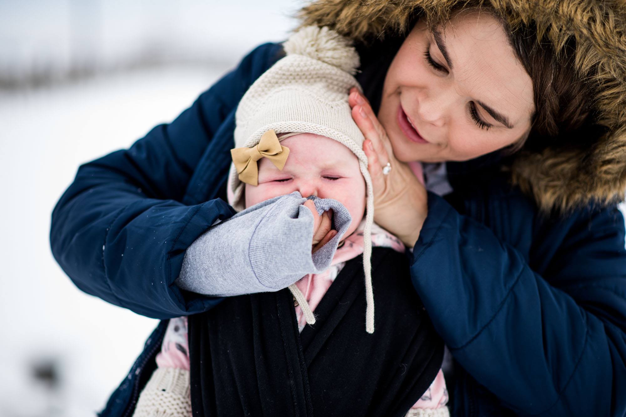 woman wipes baby's nose - Documentary Family Photography