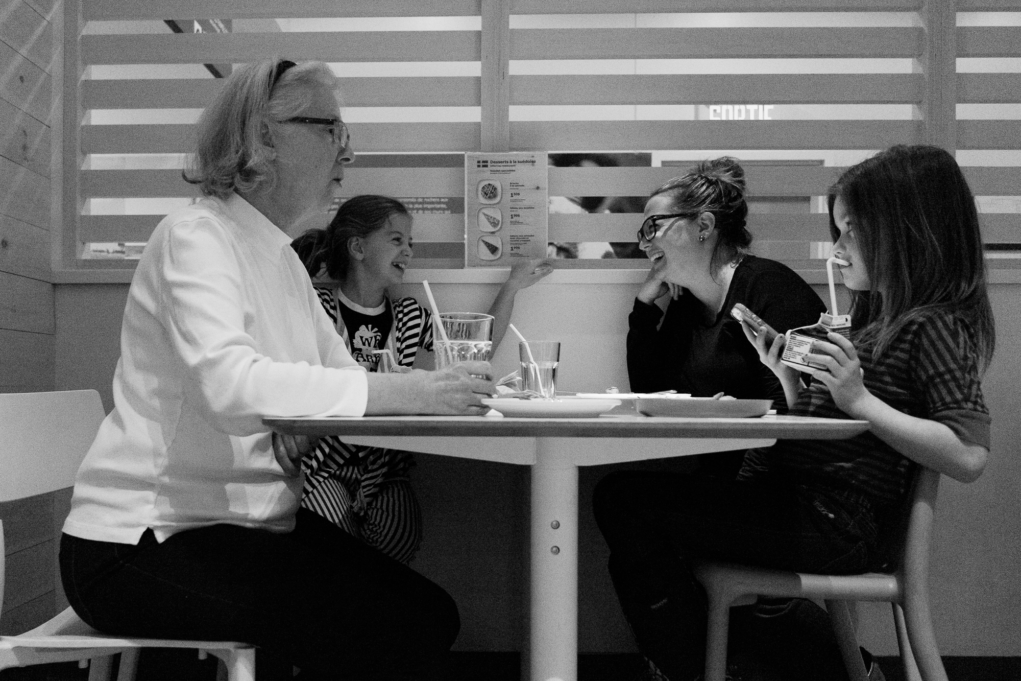 3 generations of women sit at restaurant table - documentary family photography