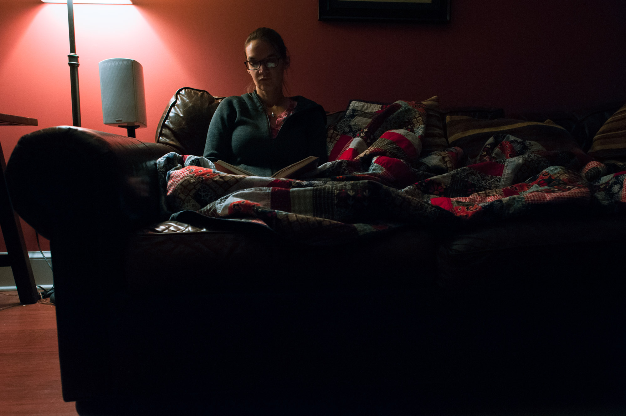 woman reads on couch at night - documentary family photography