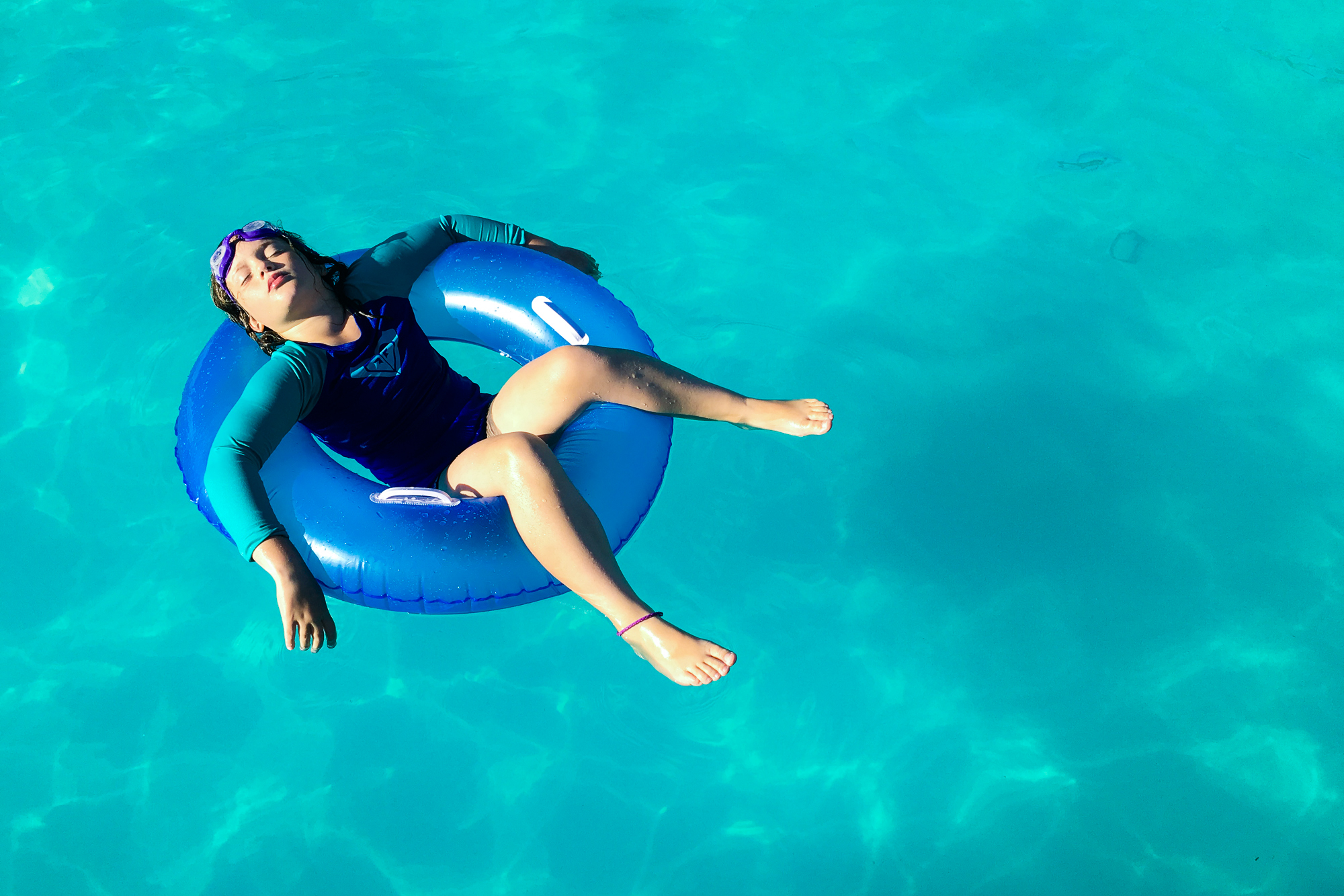 girl relaxing in pool - documentary family photography