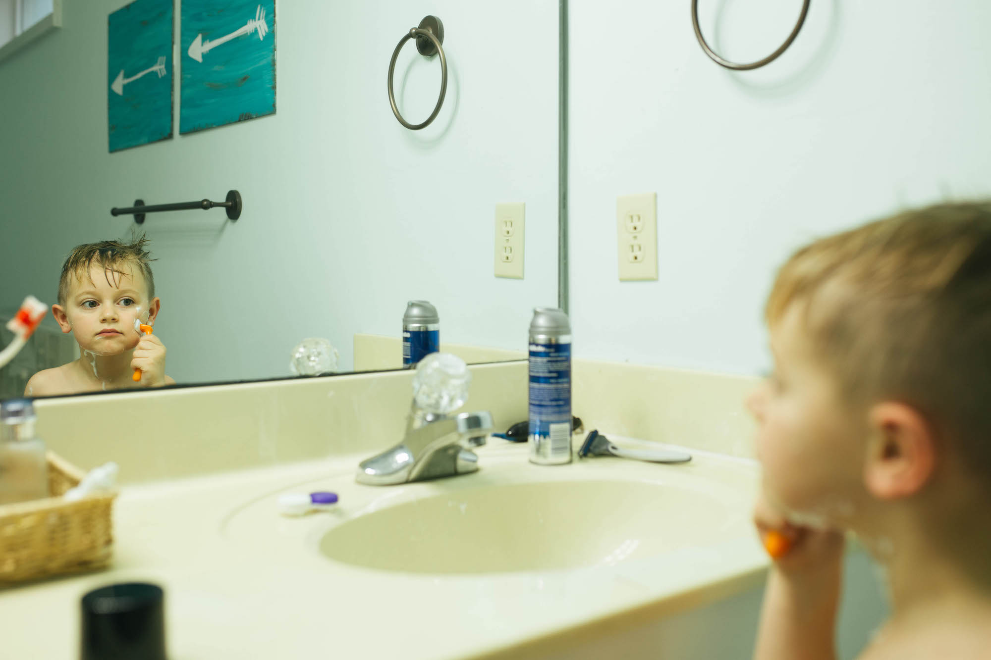 boy pretends to shave in mirror - documentary family photography
