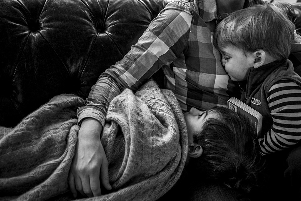 Family snuggles on couch