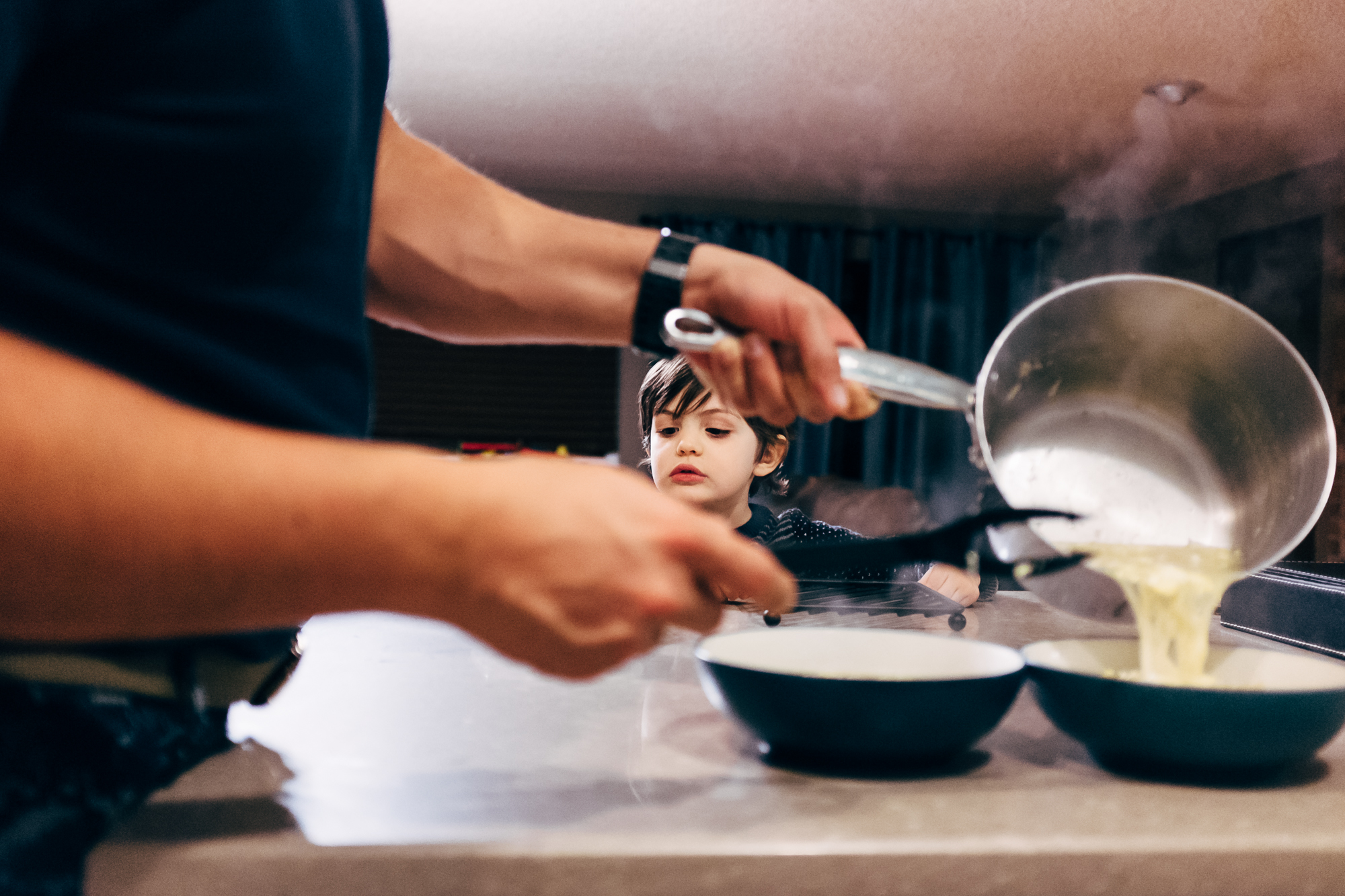 son sits as father pours soup