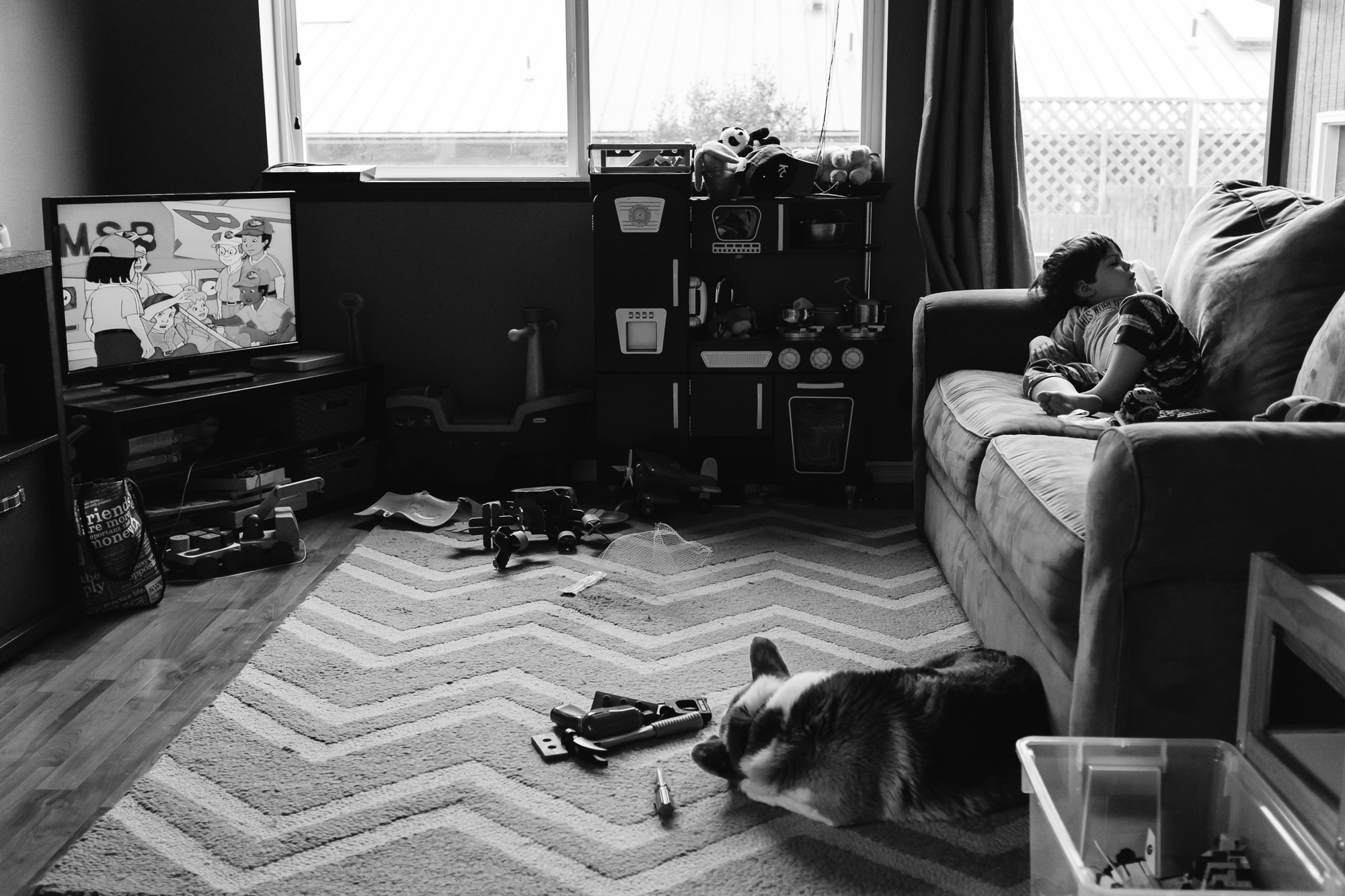 boy lounges on couch while tv is on