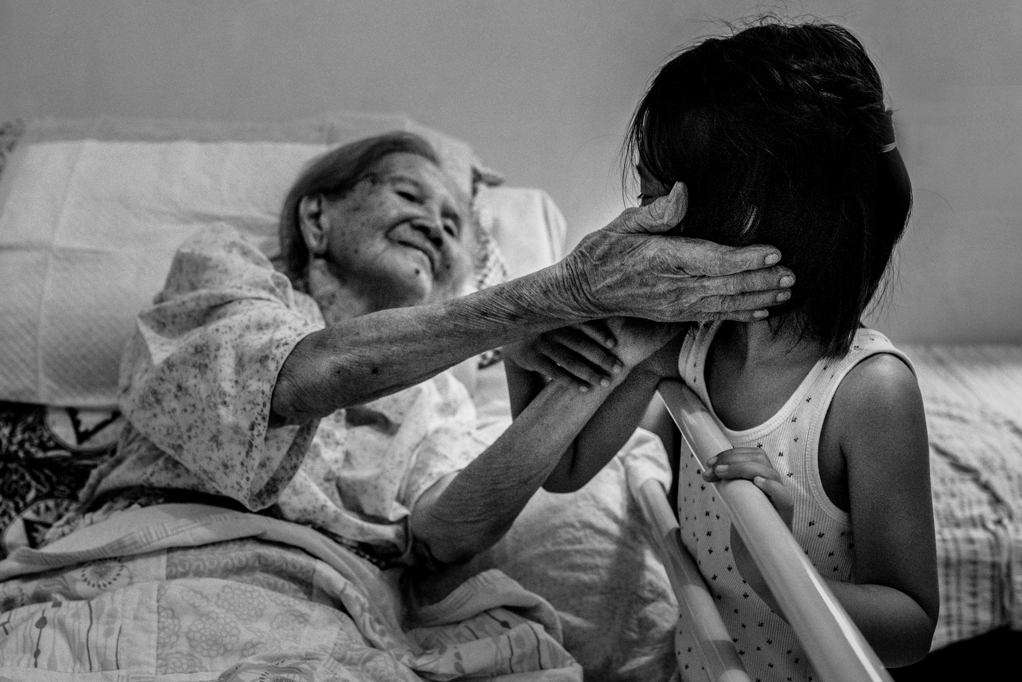 Elderly woman smiling at her great-granddaughter