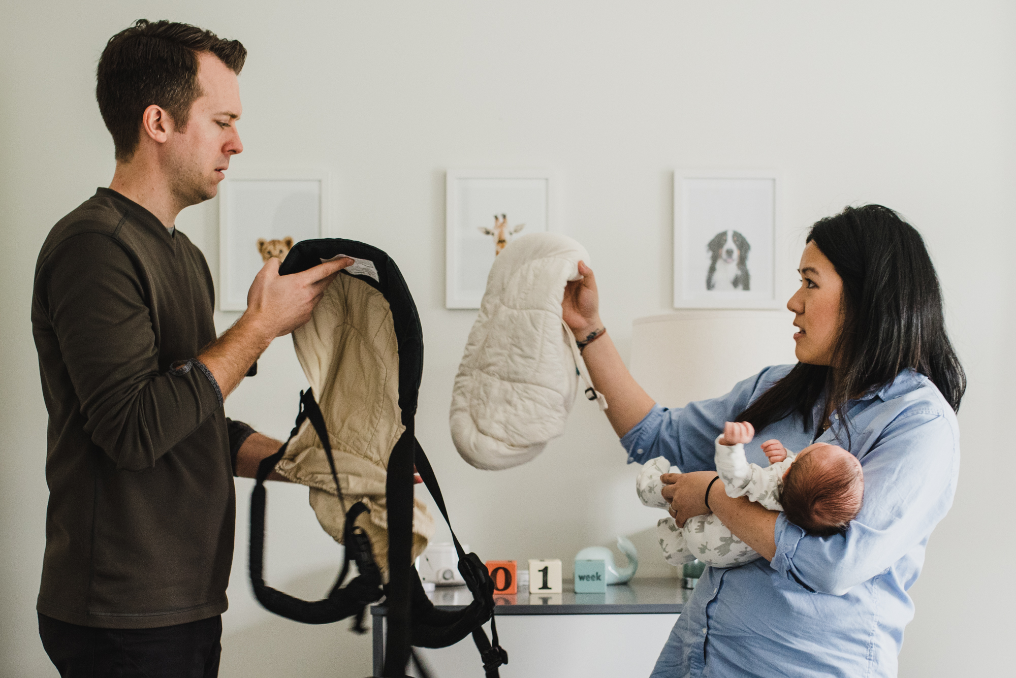 confused new parents with new baby and baby carrier