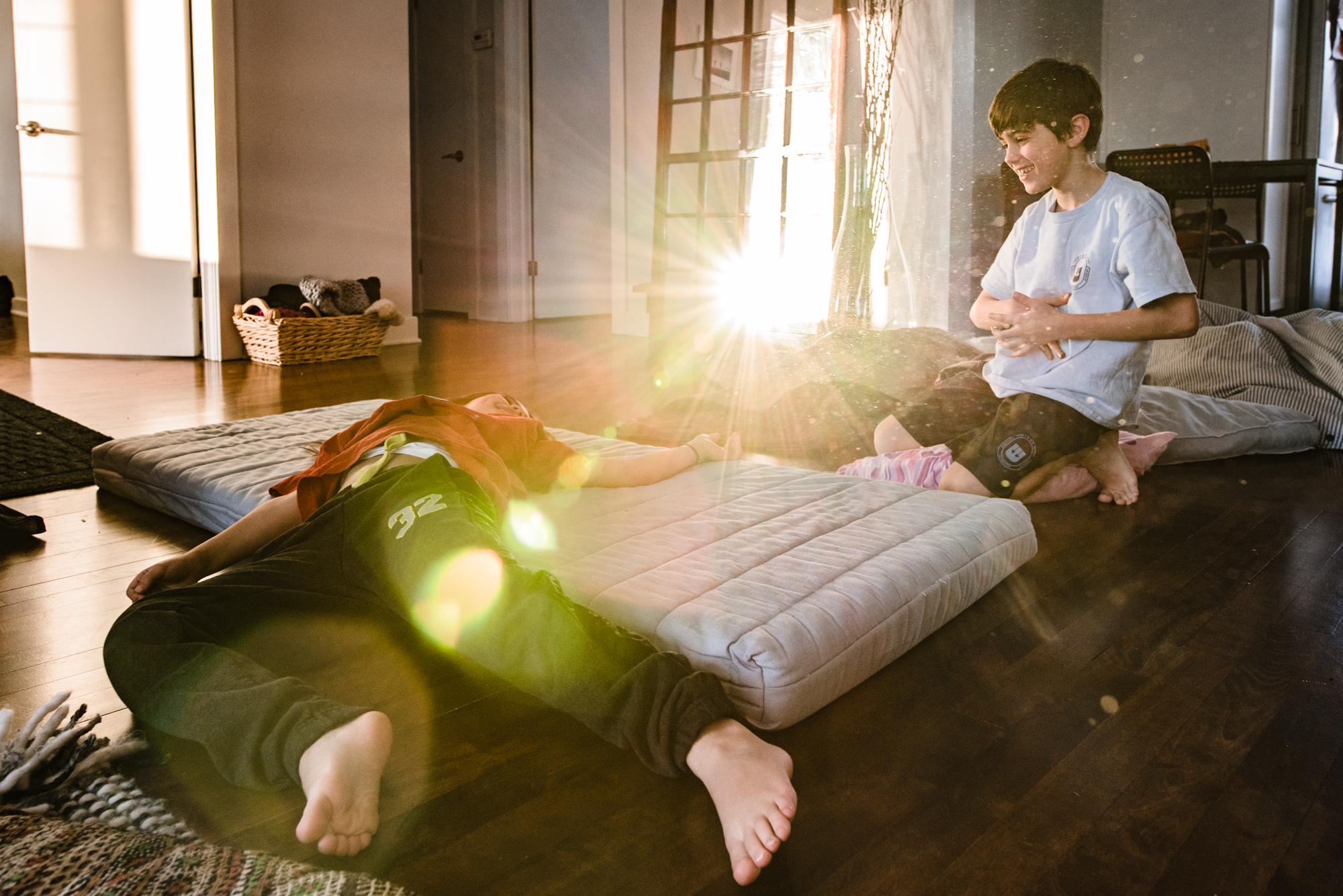 kids play on air mattress in sunlight - Documentary Family Photography