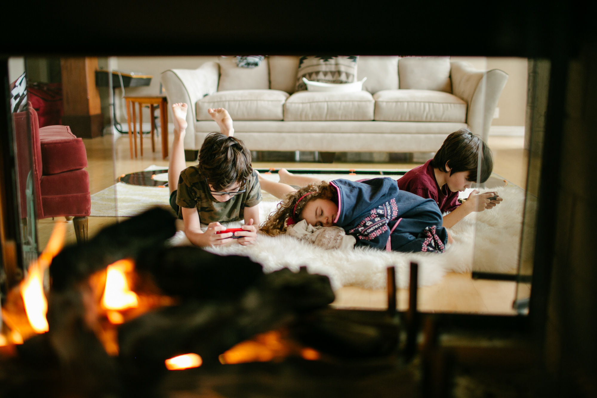 kids lounge near fireplace - Documentary Family Photography