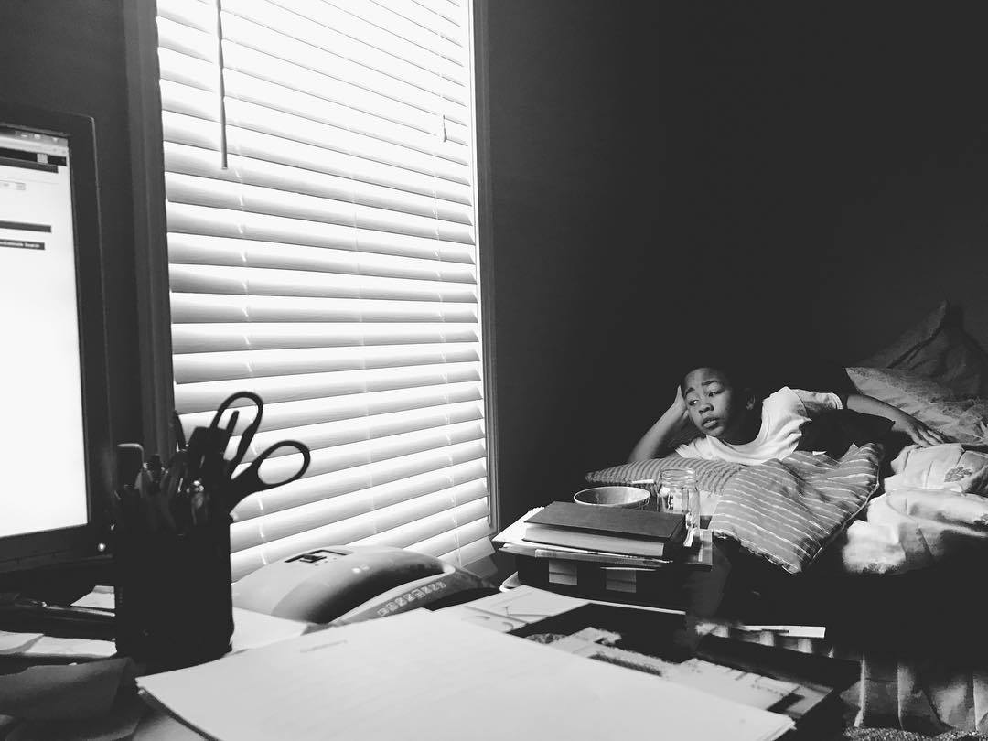 boy lounges in window light - Documentary Family Photography