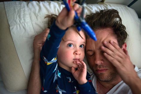 boy snuggles with tired dad - Documentary Family Photography