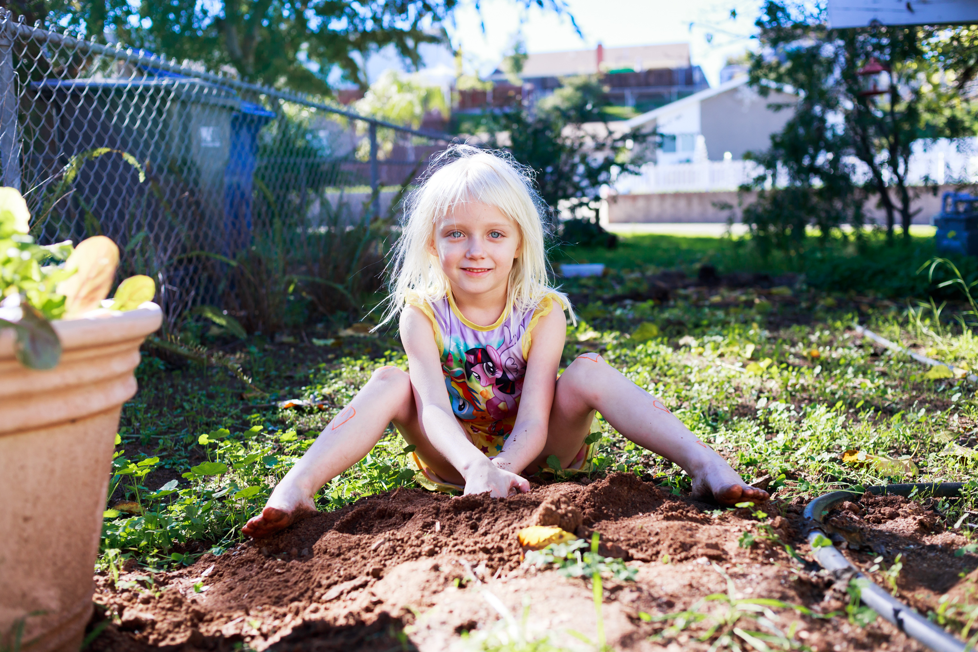 blonde girl plays in dirt 