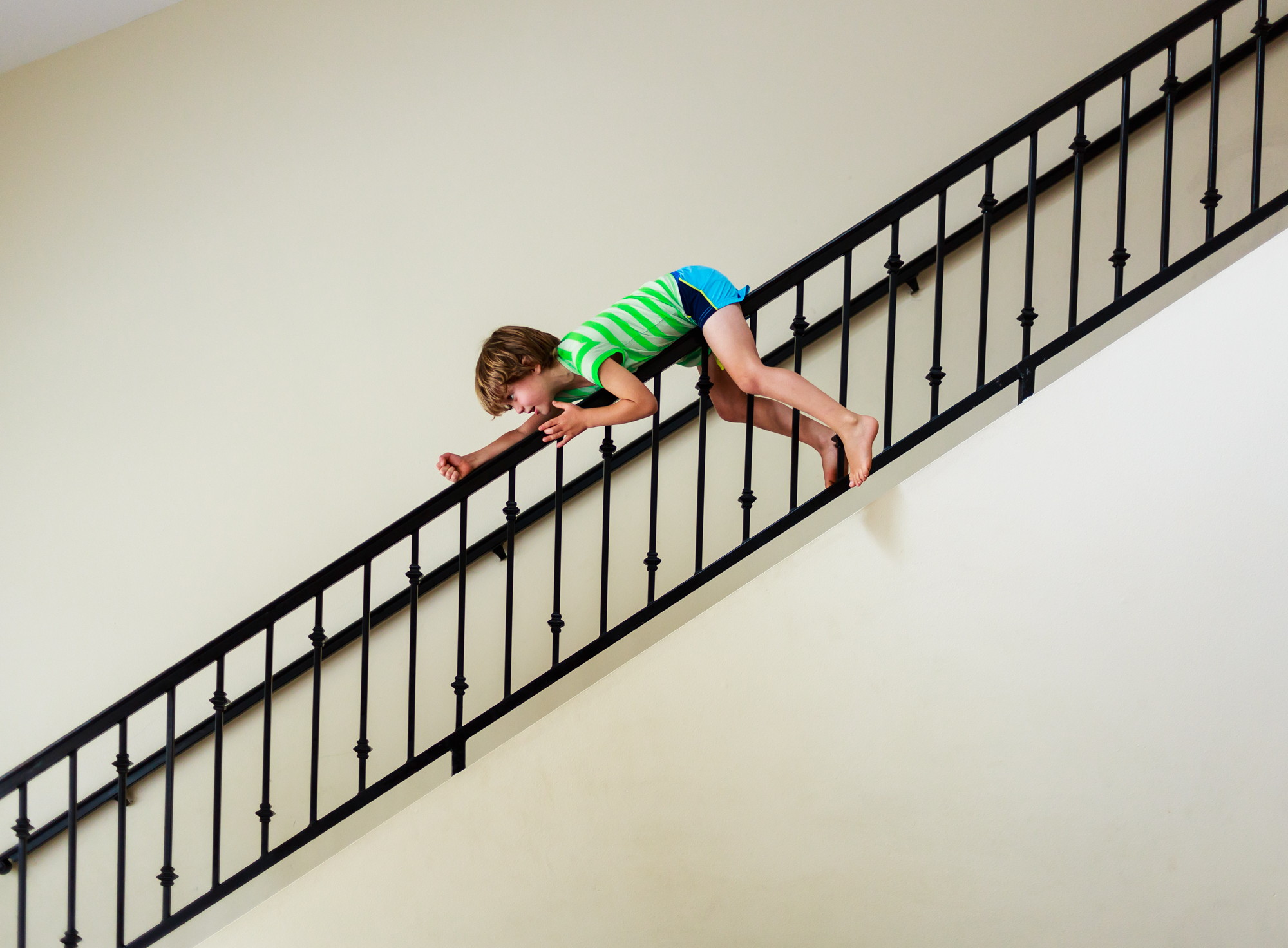 kid slides down bannister