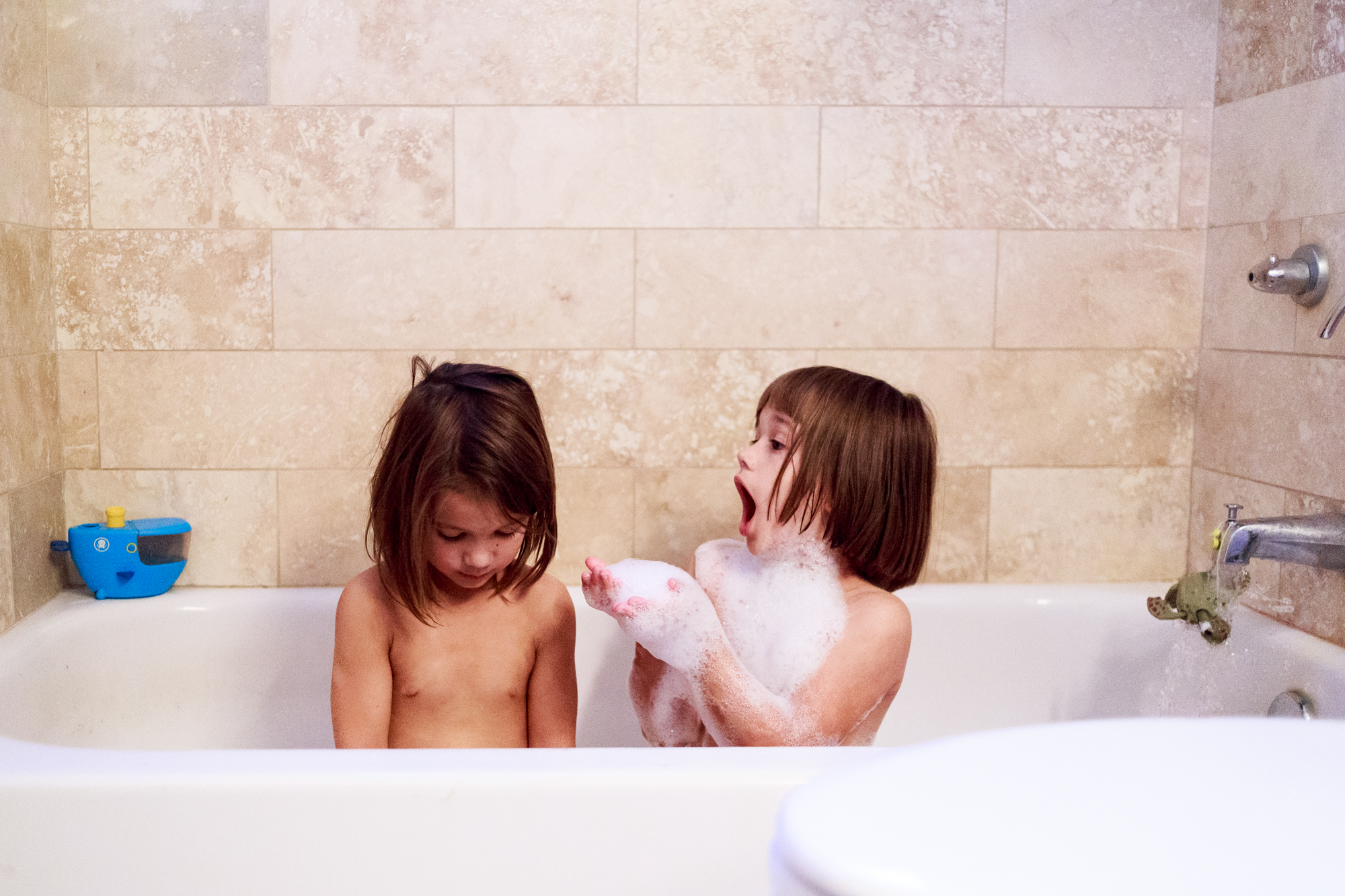 girls play with bubbles in bath