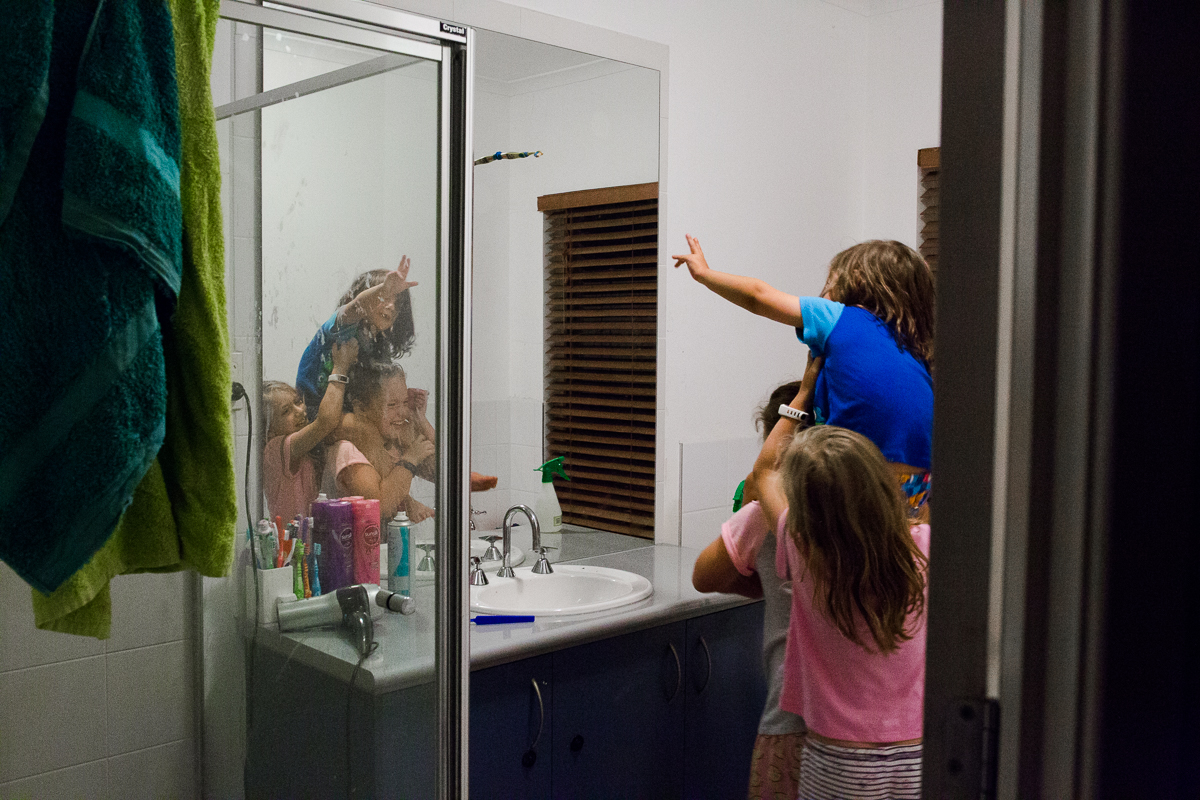 kids reach for toothbrush on mirror in bathroom - Documentary Family Photography