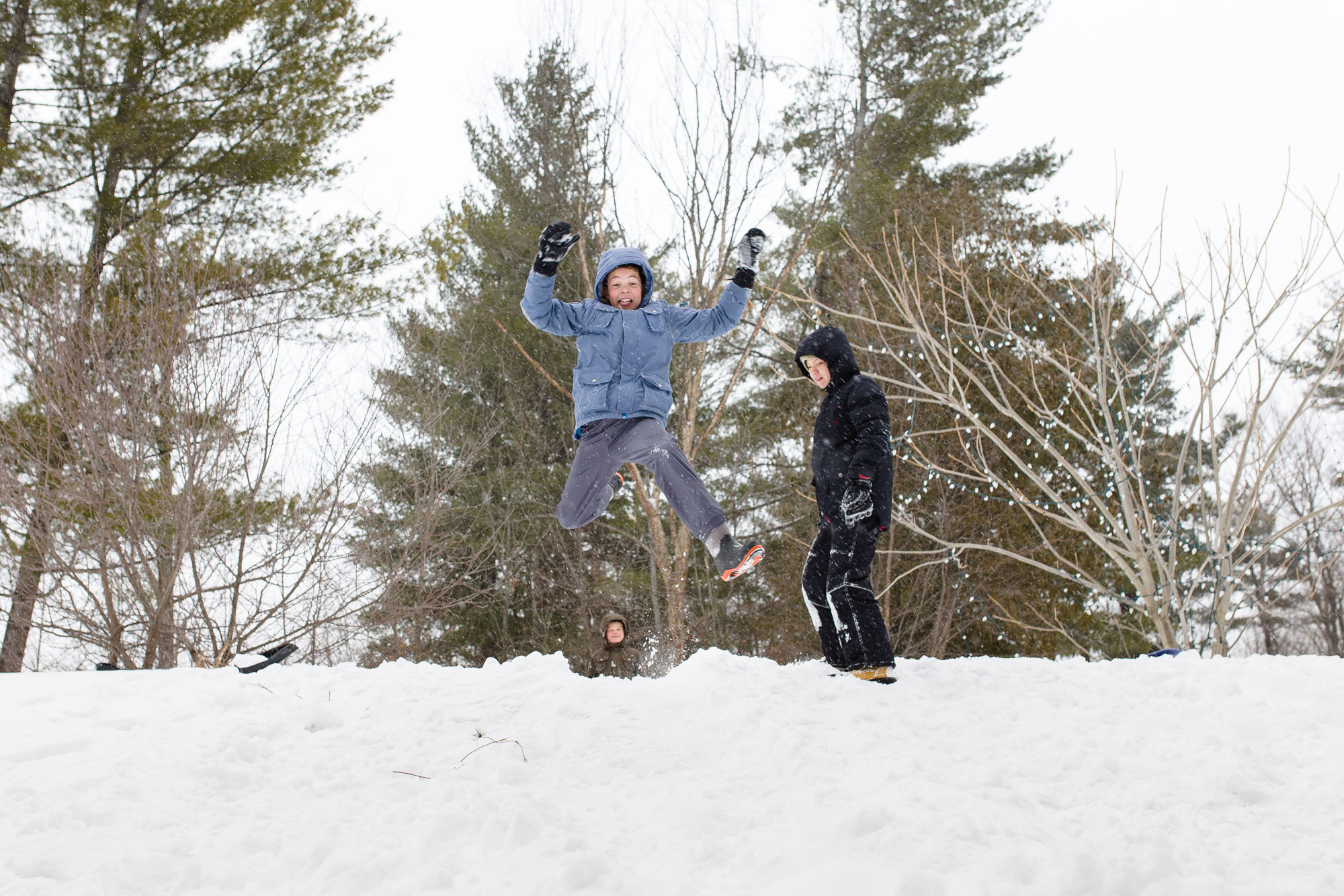 boy jumps in snow - Documentary Family Photography