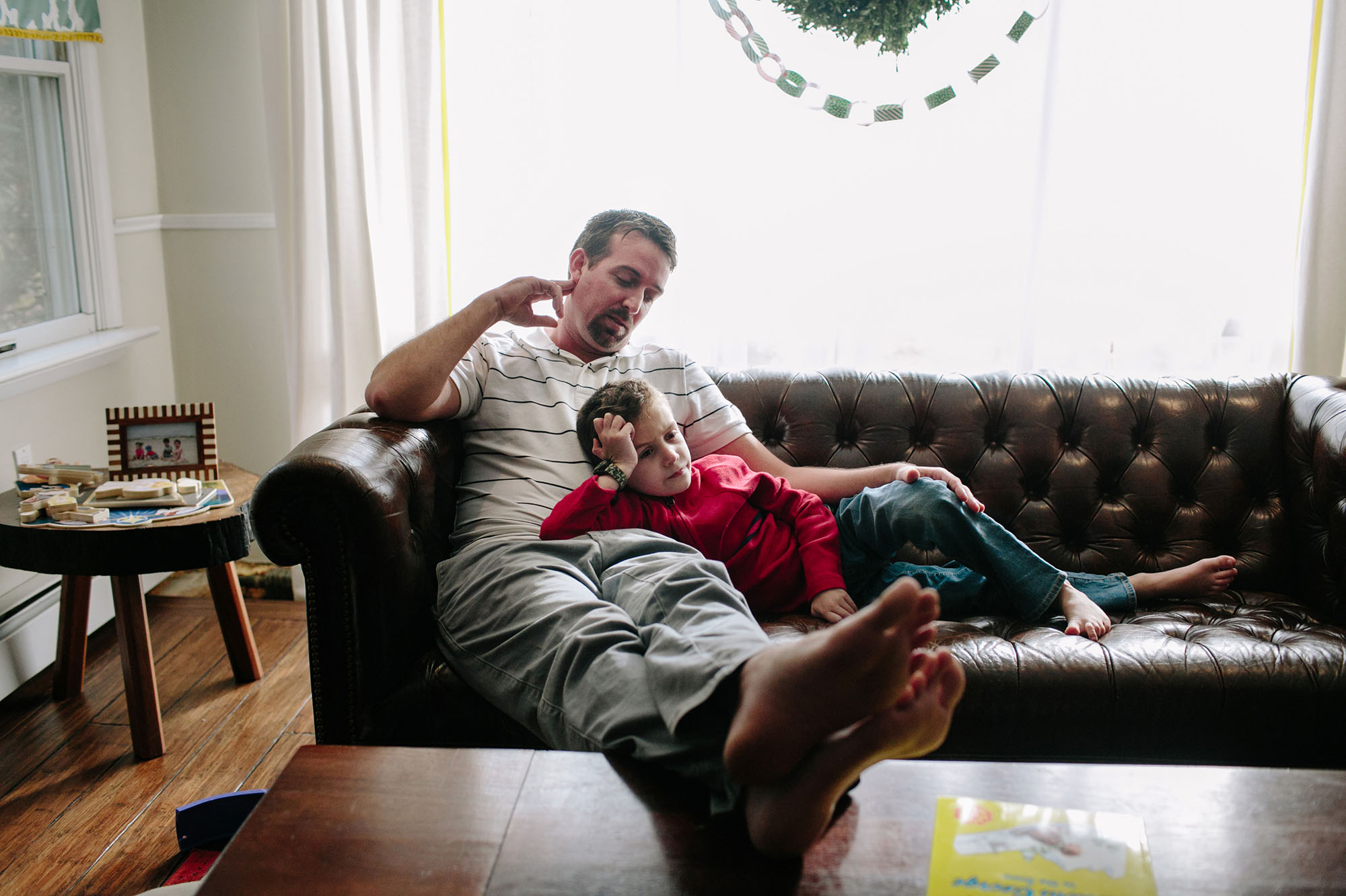 father and son on couch- documentary family photography