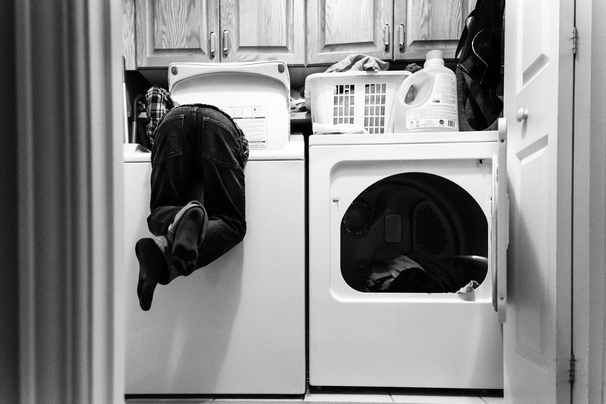 kid diving into washing machine - Documentary Family Photography