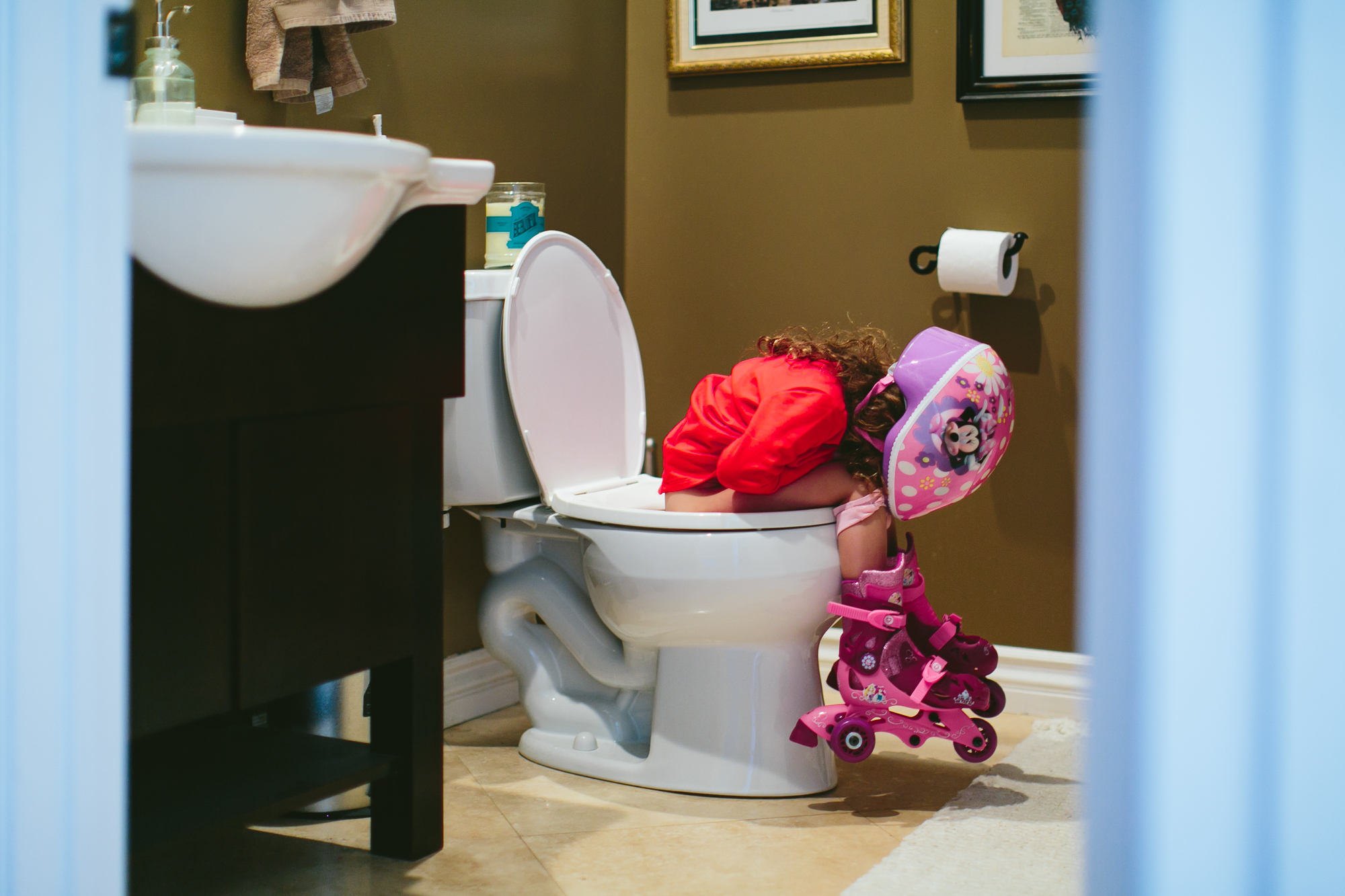 Girl in rollerblades asleep in bathroom - Documentary Family Photography
