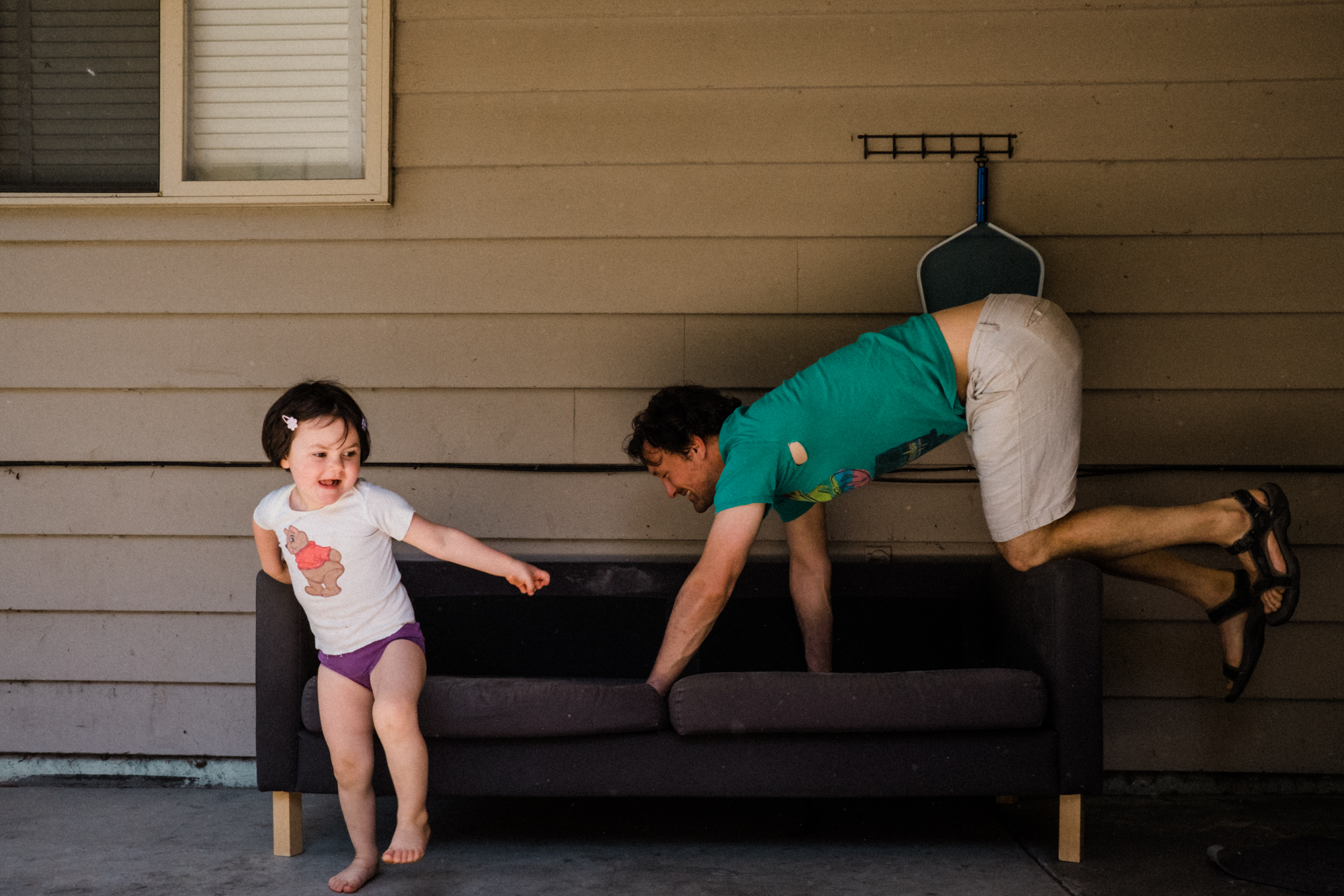 father plays with daughter on patio - Documentary Family Photography