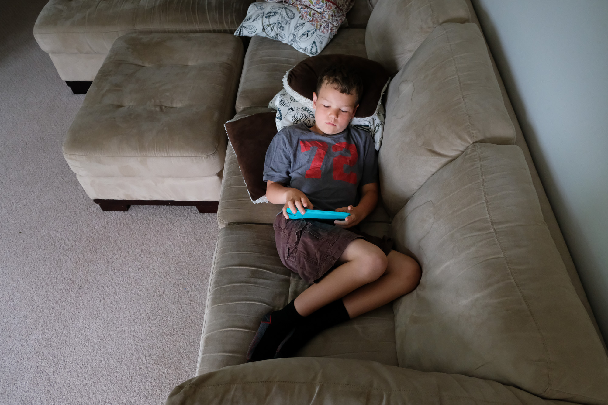 boy reads on couch - Documentary Family Photography