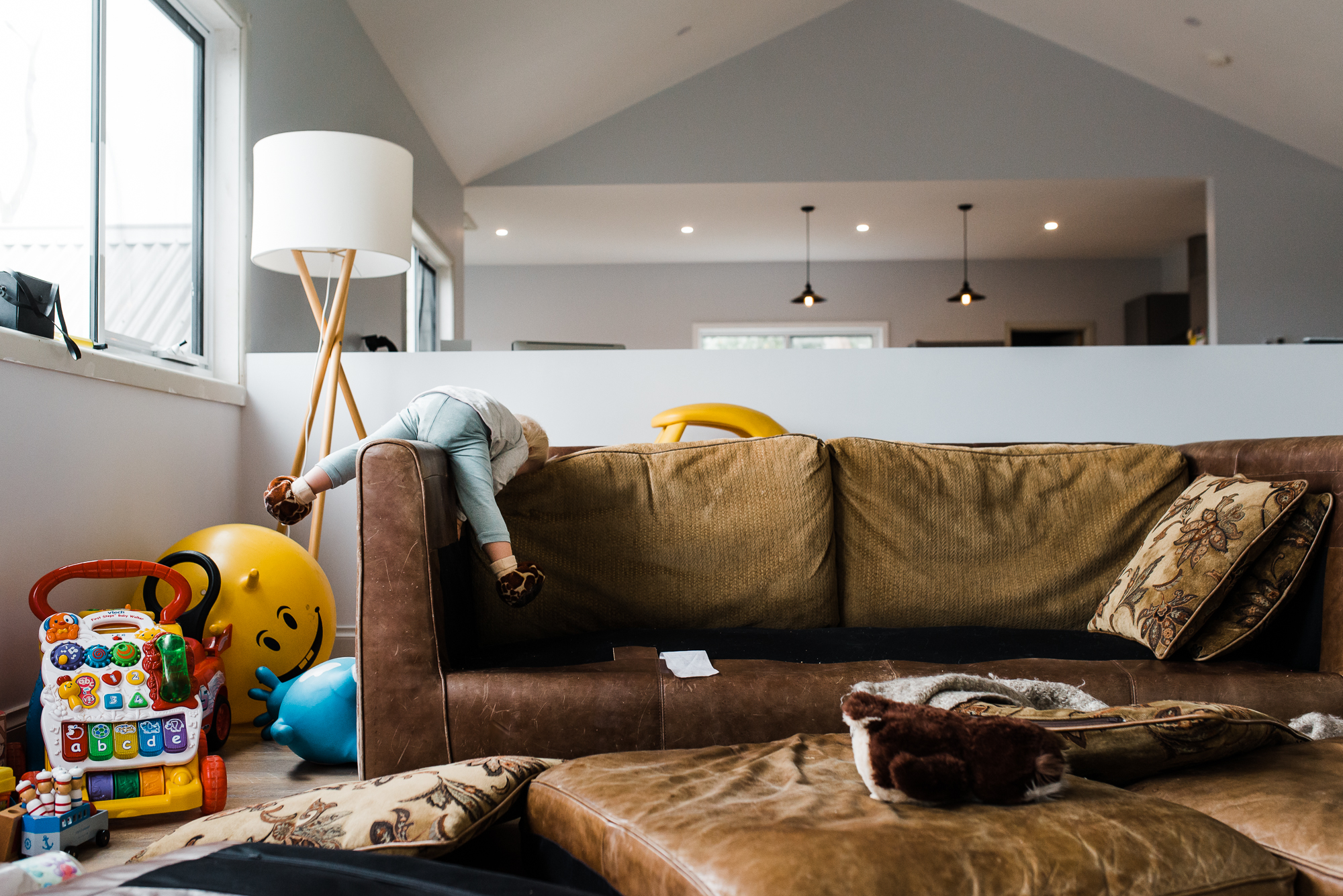 child lounges on couch - Documentary Family Photography