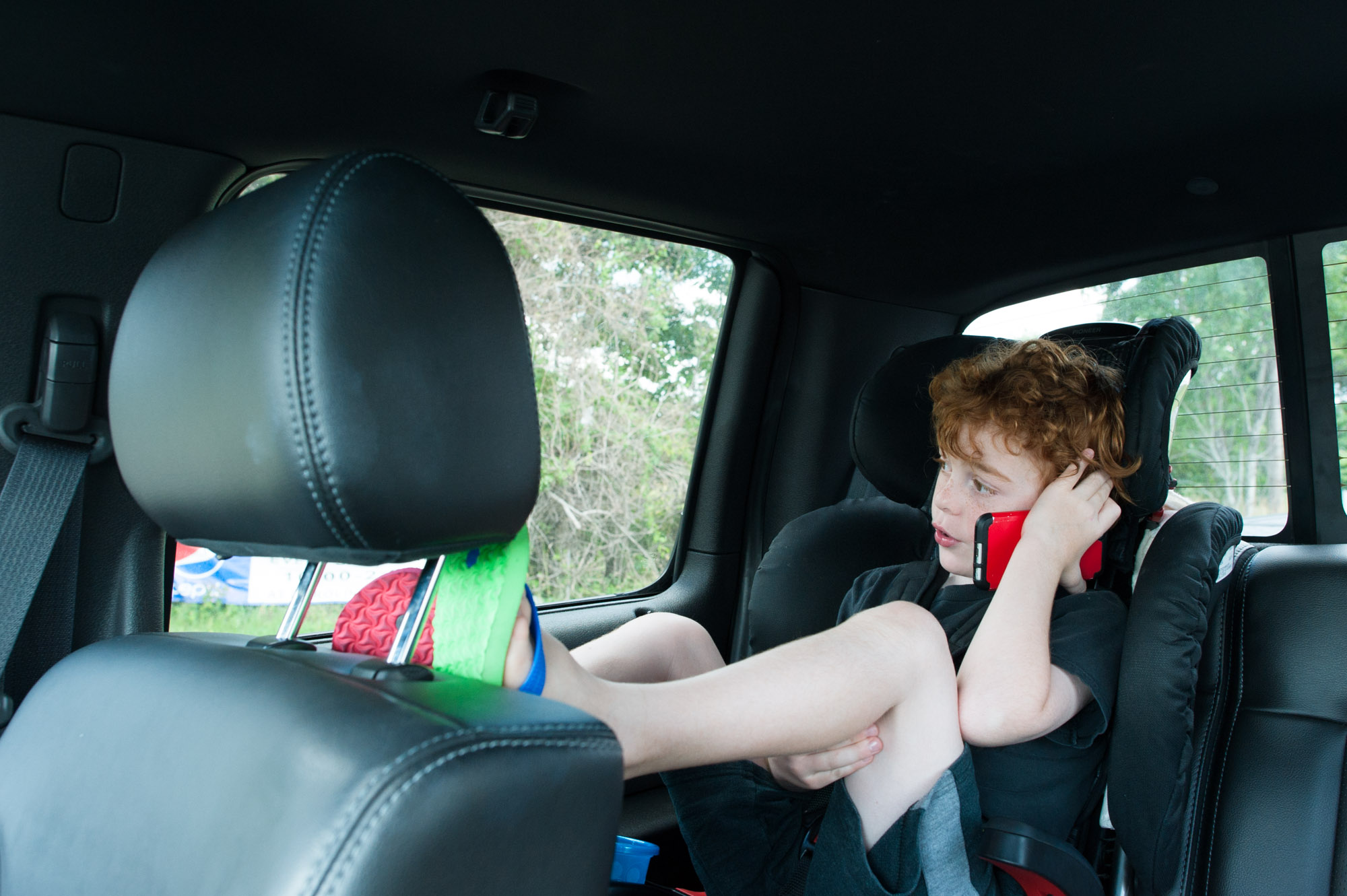 boy on toy phone in car - Documentary Family Photography