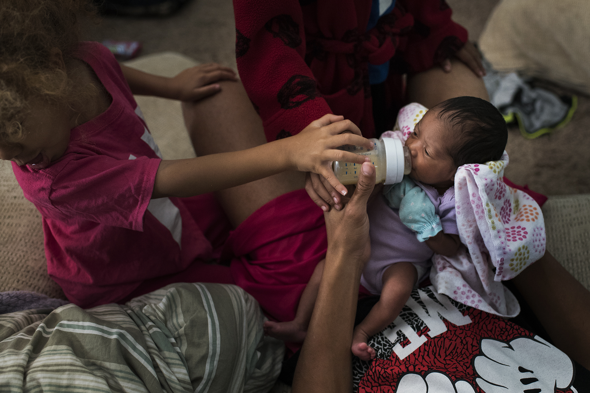 mother feeds baby - documentary family photography