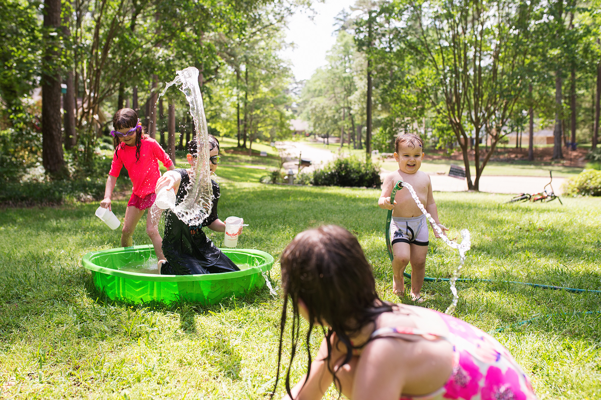 kids in pool with hoses - Documentary Family Photography