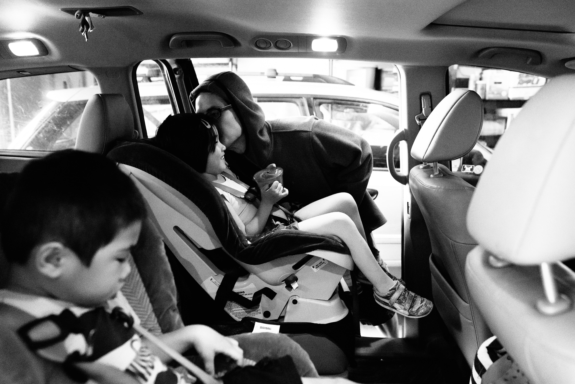 father buckles kids in car - Documentary Family Photography