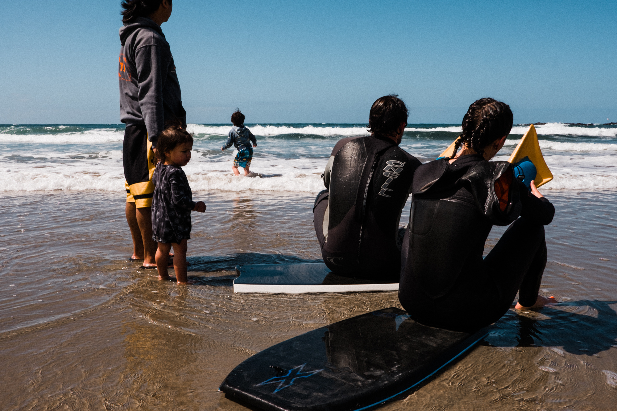 people in wet suits on beach - Documentary Family Photography