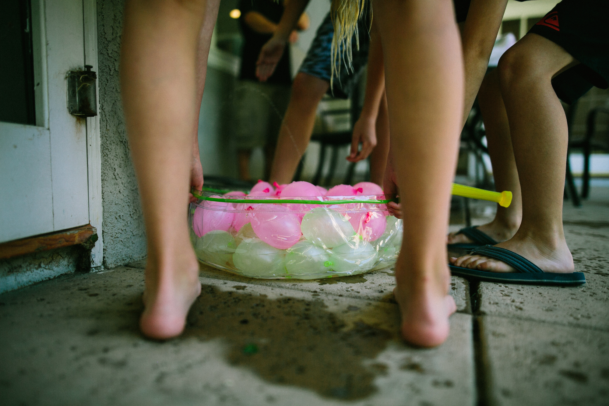 kids collect water balloons - Documentary Family Photography