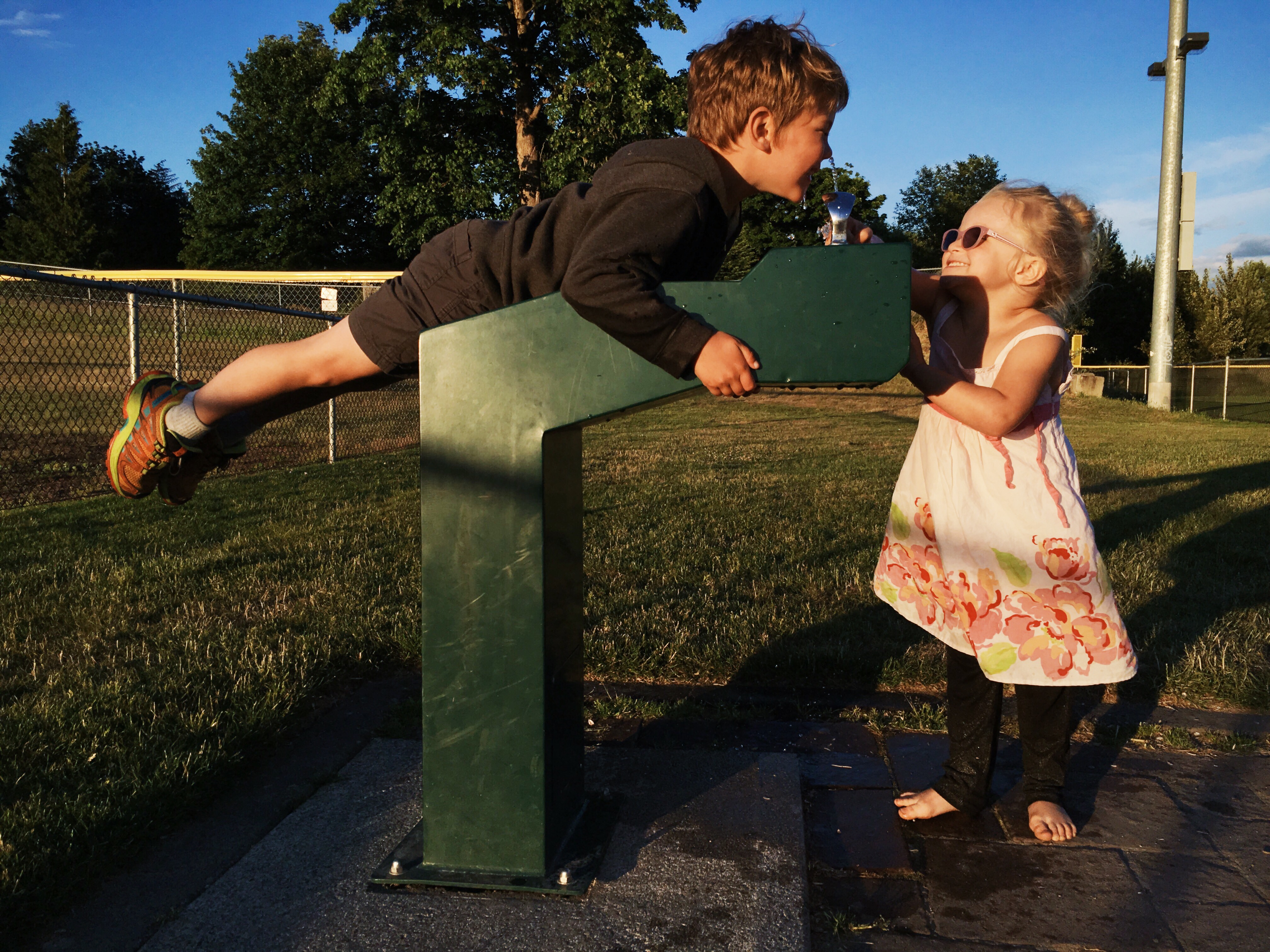 boy climbs on water fountain - documentary family photography